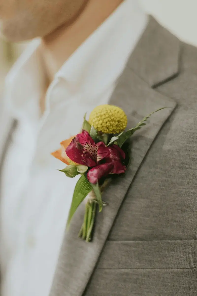 Buttonhole detail with garden herbs and soft white blooms
