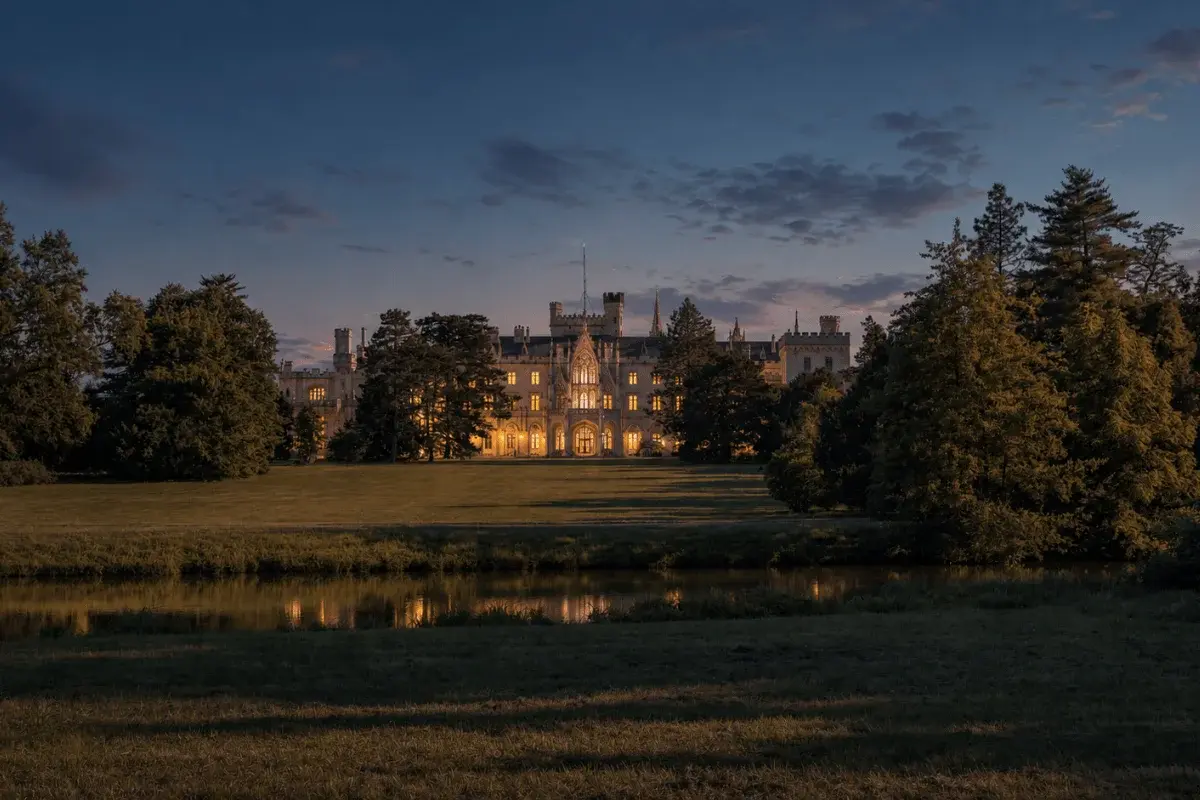 Willowmere House exterior at dusk, lights glowing in every window